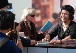 Andrea Hirata (r.) signiert seinen Roman "Die Regenbogentruppe"